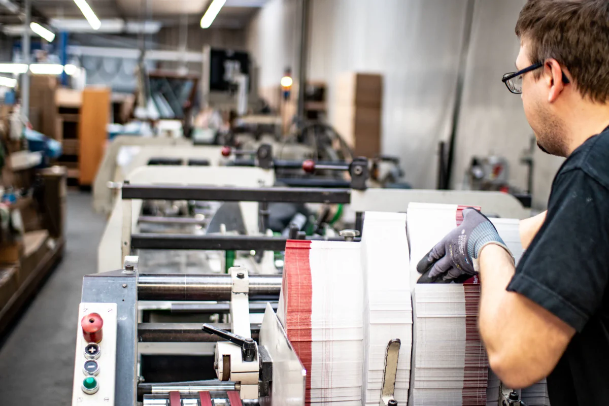 Mitarbeiter bei der Verarbeitung bedruckter Kartonzuschnitte im HvC-Werk